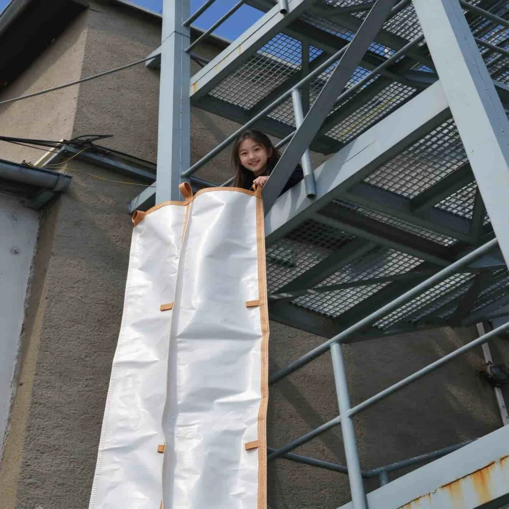 PP rubble chute fitted to a bulk bag outlet, with the operator standing beside it