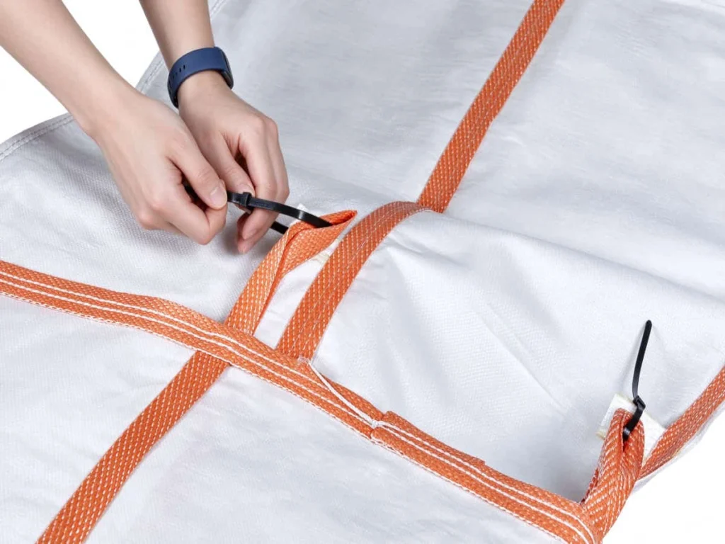 Hands joining two chute sections end to end, the upper length tied into the top of the lower one of PP CHUTE
