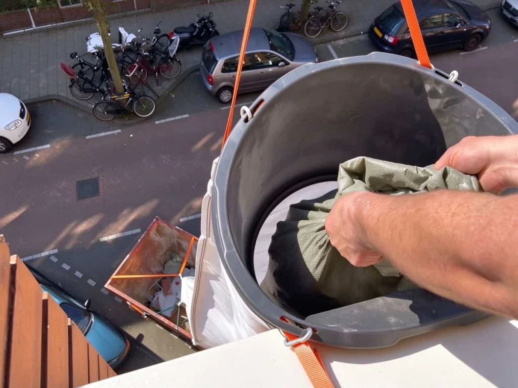Top view into the mouth of the PP chute, held open on a support hook under the filling funnel
